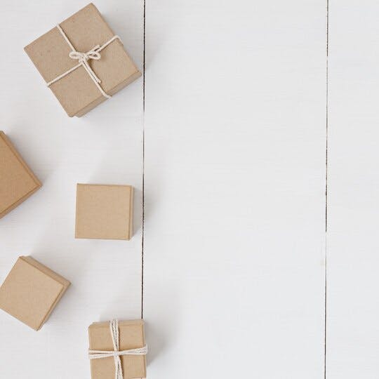 Five brown boxes, two of which are tied with twine, on a white background.