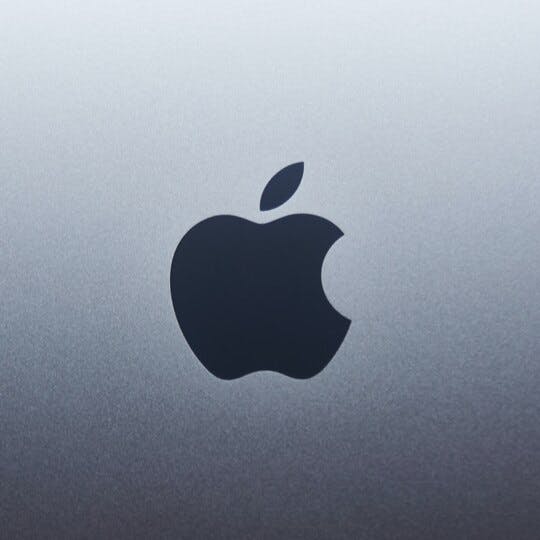 Apple logo on a background that fades from light gray to dark gray.