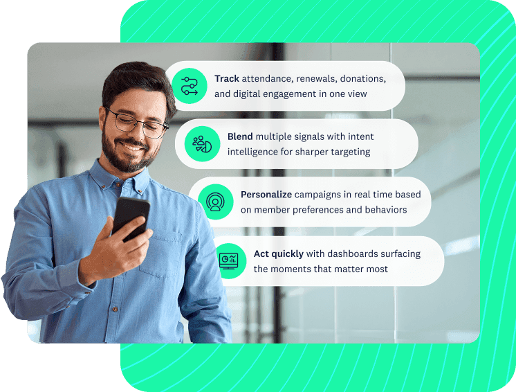 Smiling man looking down at his cellphone in an office