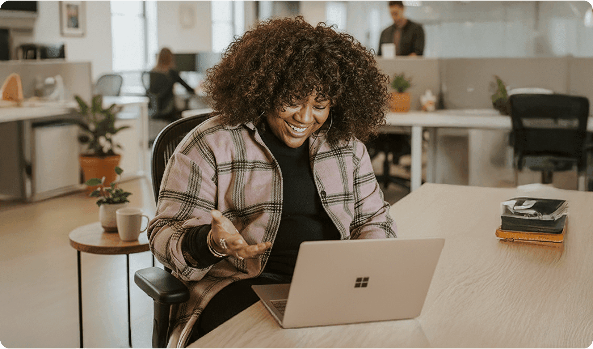 Smiling woman on video call in modern office with representing an in-house migration team.